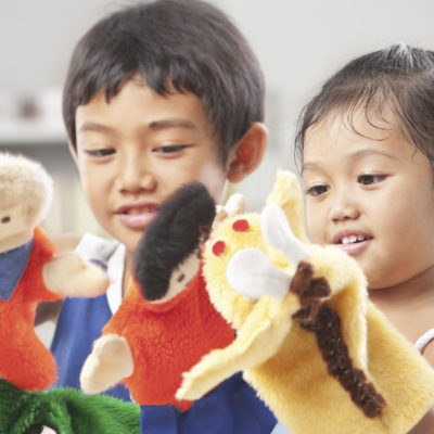 Sibling playing hand puppets, which were  handmade